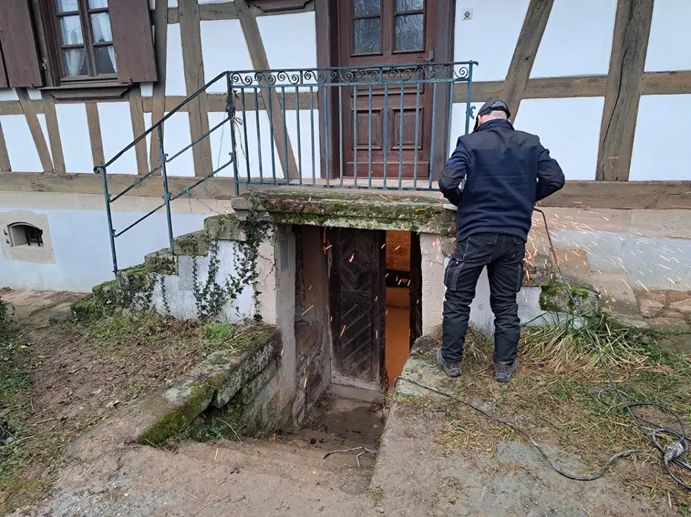 Homme devant une entrée de cave